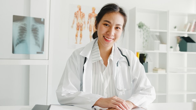 Fiducioso giovane medico femminile asiatico in uniforme medica bianca con lo stetoscopio