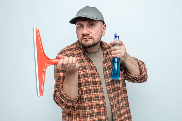 Fiducioso pulitore slavo uomo che tiene tergipavimento e detergente spray