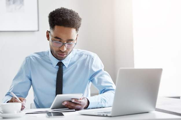 Fiducioso uomo d'affari che lavora al suo computer portatile