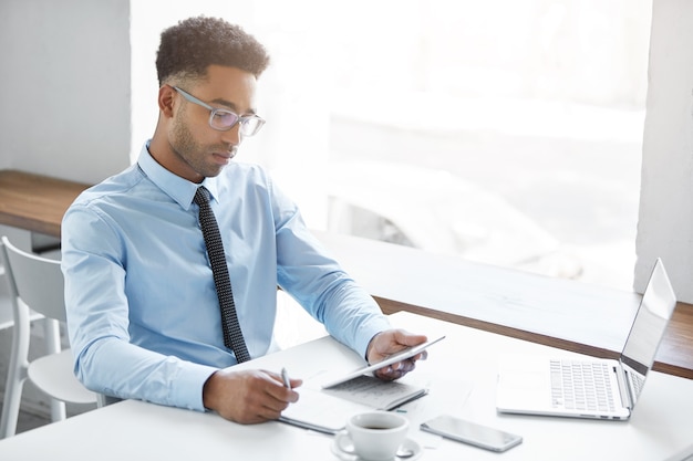 Fiducioso uomo d'affari che lavora al suo computer portatile