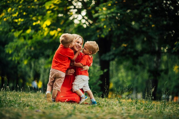 Figli che abbracciano la loro madre nel parco