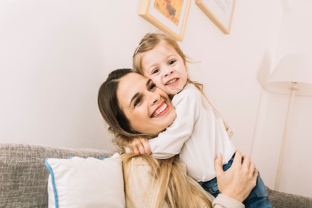 Figlia che abbraccia la madre sul divano