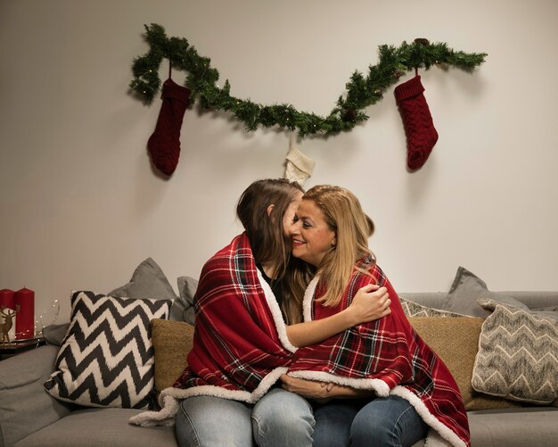 Figlia che abbraccia sua madre per natale