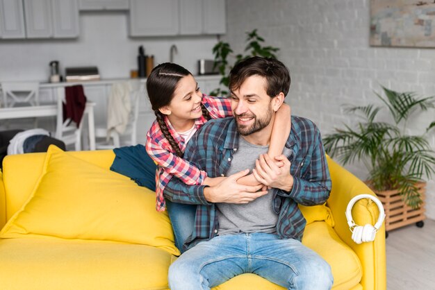 Figlia che abbraccia suo padre in salotto