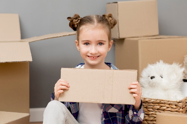 Figlia che aiuta con le scatole di imballaggio