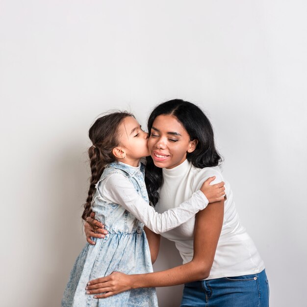 Figlia che bacia la mamma sulla guancia