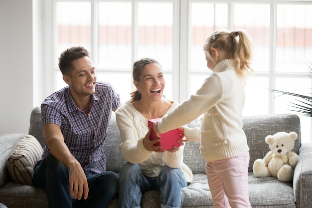 Figlia che dà il contenitore di regalo della mamma che presenta il giorno di madri