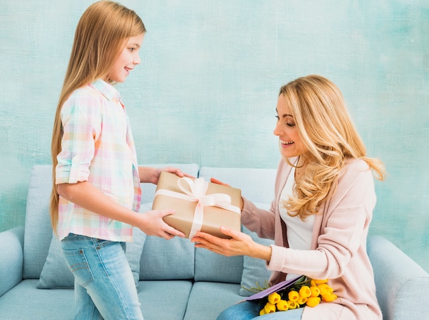 Figlia che dà scatola regalo per la madre