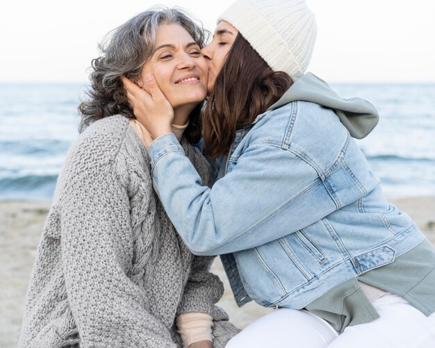 Figlia che ha un momento tenero con la madre in spiaggia