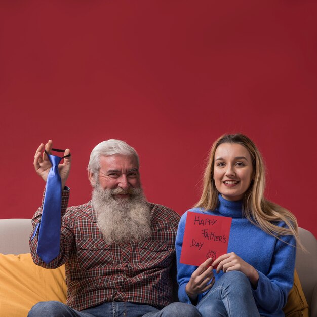 Figlia che tiene una cartolina d'auguri di festa del papà