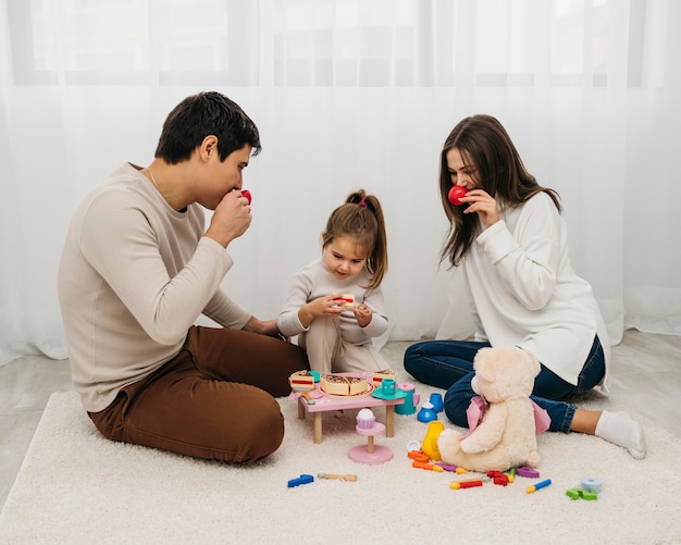 Figlia e genitori che giocano insieme a casa