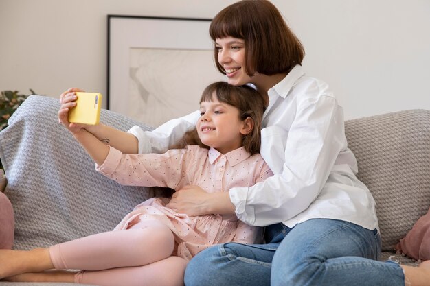 Figlia e madre a tiro medio che si fanno selfie