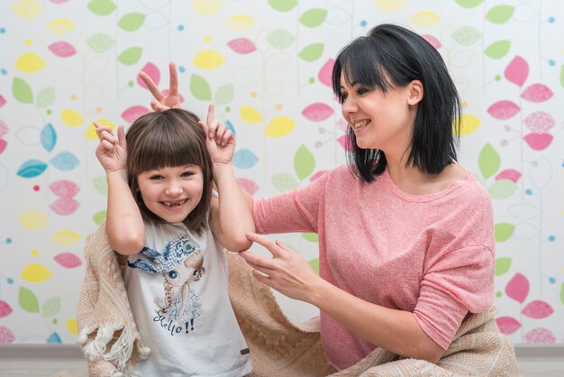 Figlia e madre che fanno le corna con le dita