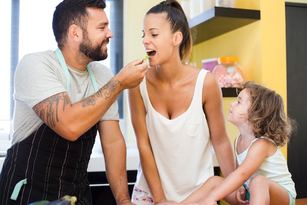 Figlia guardando padre che alimenta peperone a sua madre