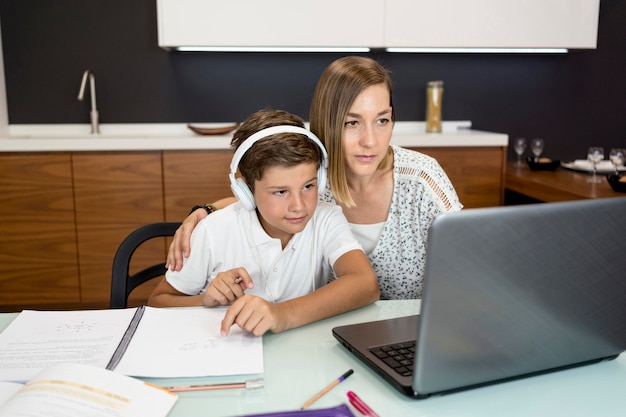 Figlio d'aiuto della madre con i compiti