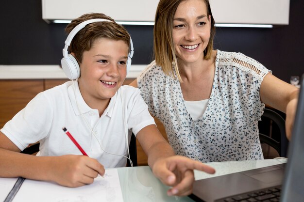 Figlio d'aiuto della madre con i compiti