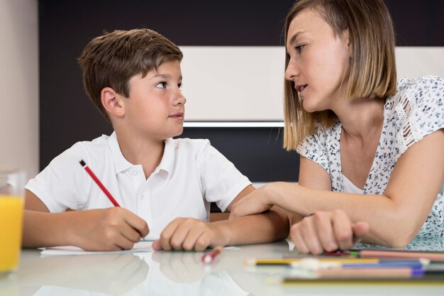 Figlio d'aiuto della madre con i compiti