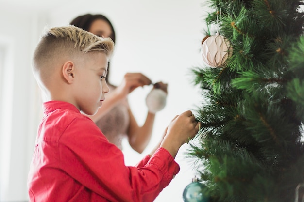 Figlio e madre che decora l&#39;albero di Natale