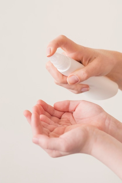 Figlio e mamma usando disinfettante per le mani