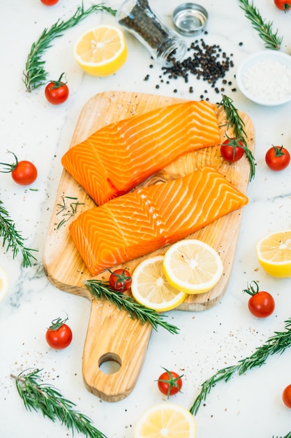 Filetto di carne di salmone crudo e fresco sul tagliere di legno