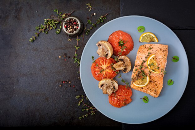 Filetto di pesce al salmone al forno con pomodori, funghi e spezie. Menu dietetico.