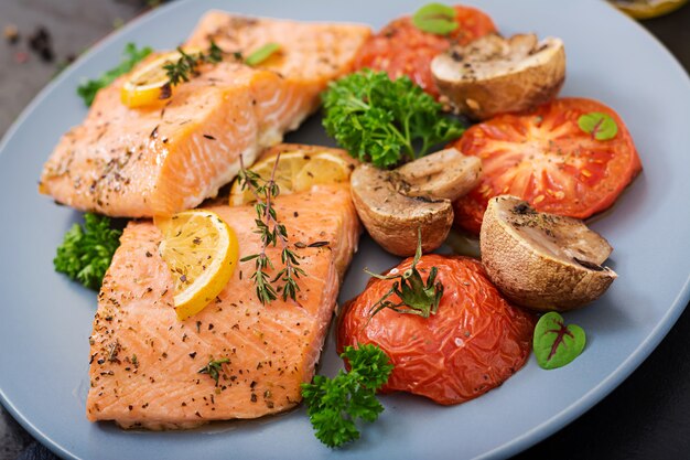 Filetto di pesce al salmone al forno con pomodori, funghi e spezie. Menu dietetico.