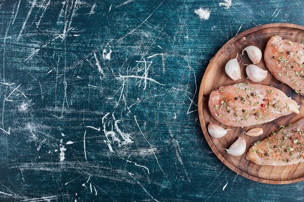 Filetto di pollo crudo con spezie e aglio.