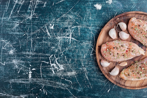 Filetto di pollo crudo con spezie e aglio.