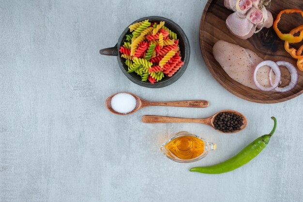 Filetto di pollo e verdure sul piatto di legno con maccheroni.