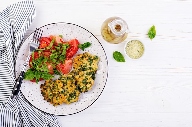 Filetto di pollo tritato con bistecca al forno con spinaci e contorno di insalata di pomodori. Cucina europea. Cibo dietetico. Vista dall'alto