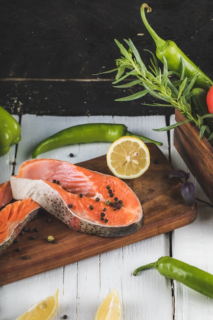 Filetto di salmone sulla tavola di legno con limone e rosmarino