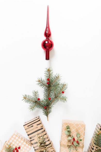 Filiale di albero di abete con albero di Natale giocattolo e regali