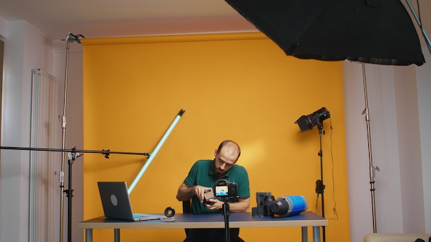 Filmmaker che registra la presentazione della testa fluida del treppiede per vlog. Discussione sugli accessori per la videografia. Tecnologia professionale per attrezzature video e fotografiche da studio per il lavoro, social media per studi fotografici s