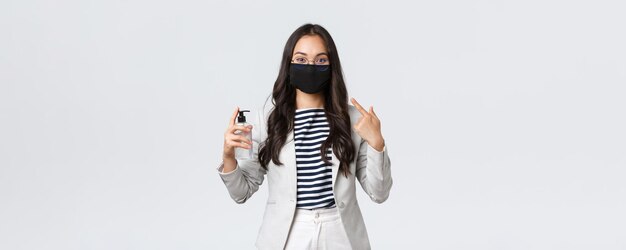 Finanza aziendale e occupazione covid19 prevenzione virus e concetto di allontanamento sociale La signora asiatica carina dell'ufficio spiega l'importanza di indossare maschere per il viso e utilizzare disinfettanti per le mani durante la pandemia