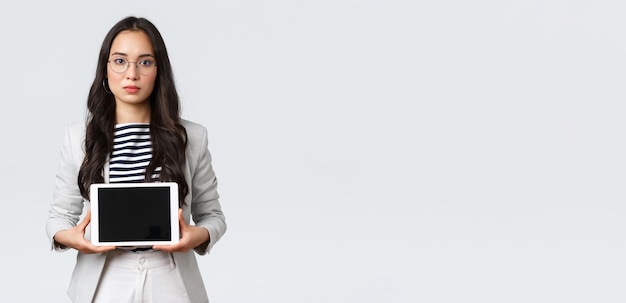 Finanza aziendale e occupazione imprenditrici di successo concetto Seriouslooking office manager dipendente donna asiatica che presenta il suo prodotto sul display tablet digitale
