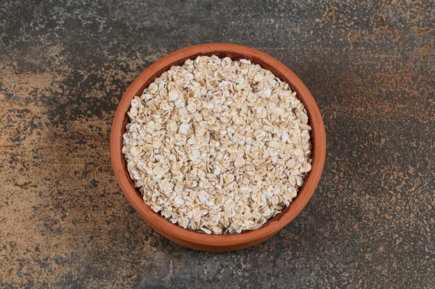 Fiocchi d'avena secchi in una ciotola di ceramica.