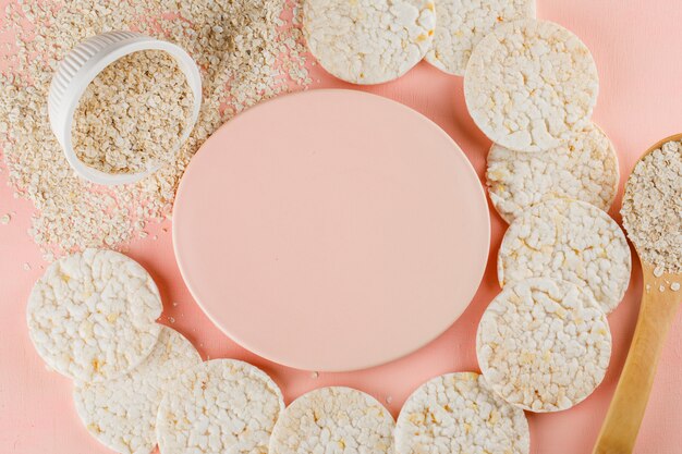 Fiocchi di avena in ciotola e cucchiaio di legno con torte di riso