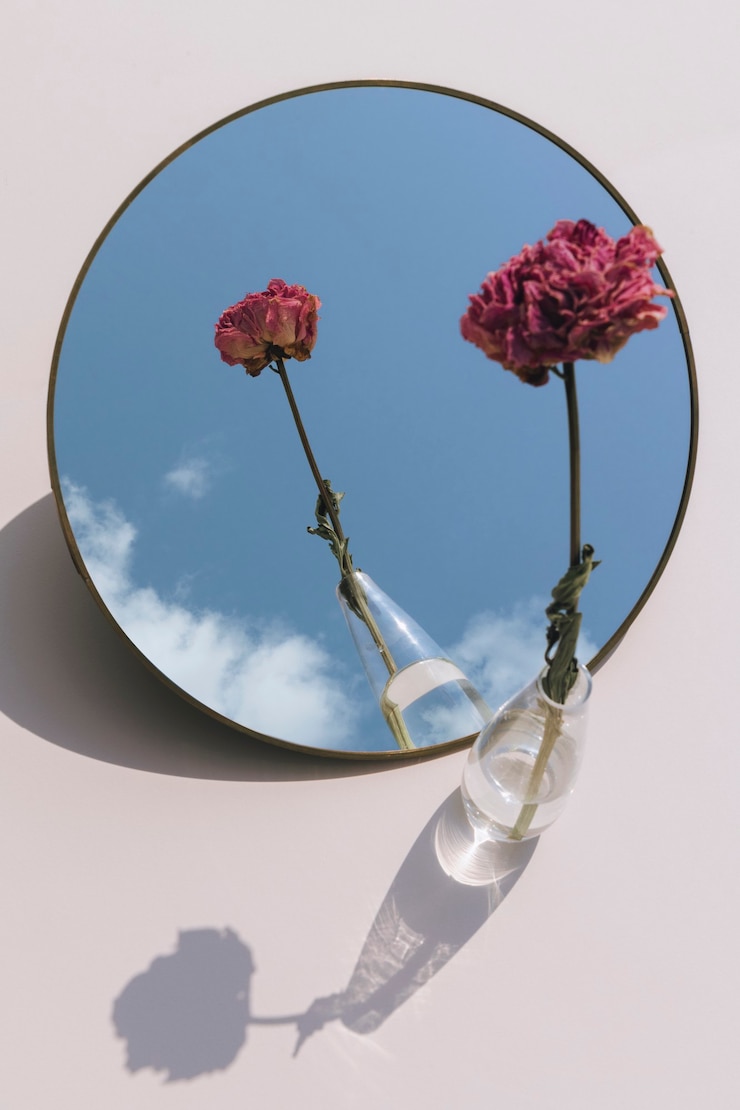 Foto gratuito fiore di peonia rosa essiccato in un vaso trasparente riflesso su uno specchio