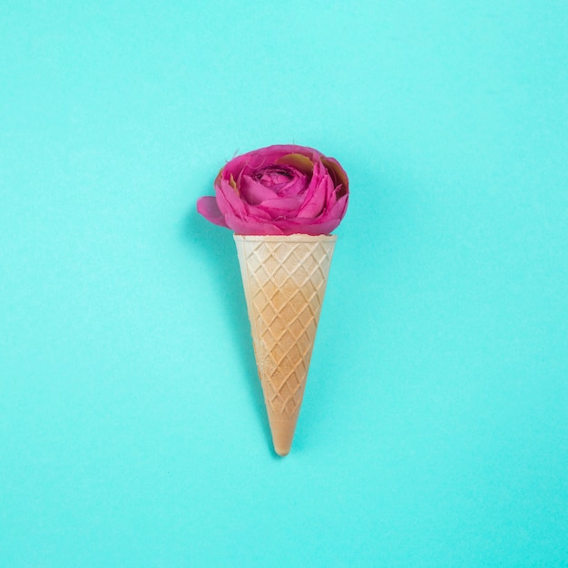 Fiore di rosa nel cono di cialda sul tavolo