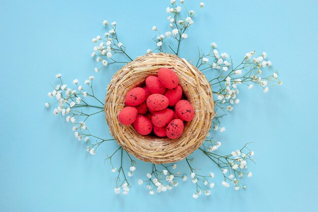 Fiori accanto al cestino con le uova per pasqua