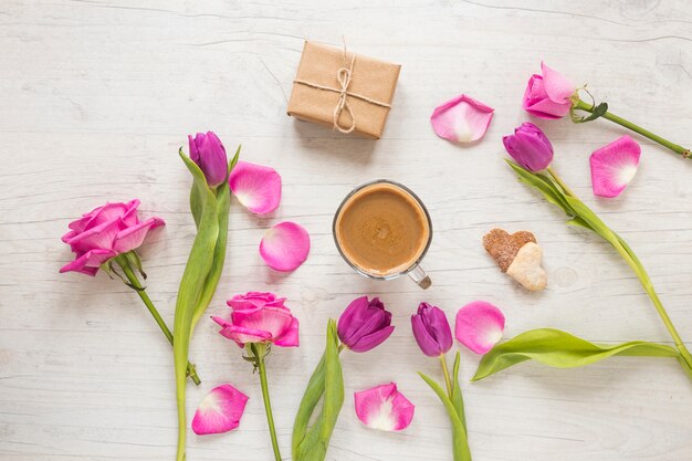 Fiori con scatola regalo e caffè sul tavolo