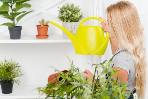 Fiori d'innaffiatura della ragazza di vista laterale