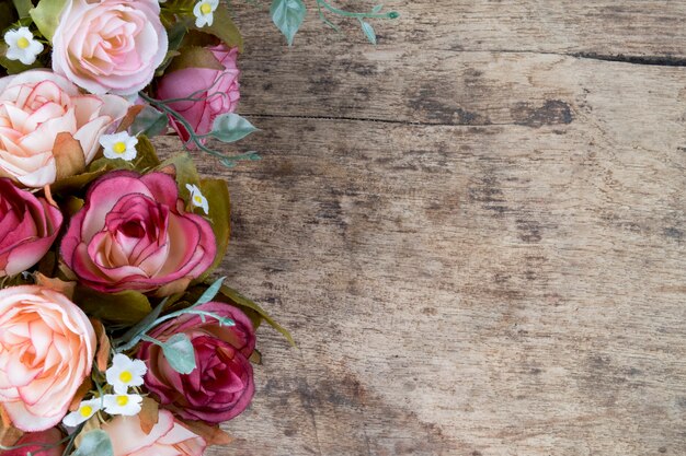 Fiori di rosa su sfondo rustico di legno. Copia spazio.