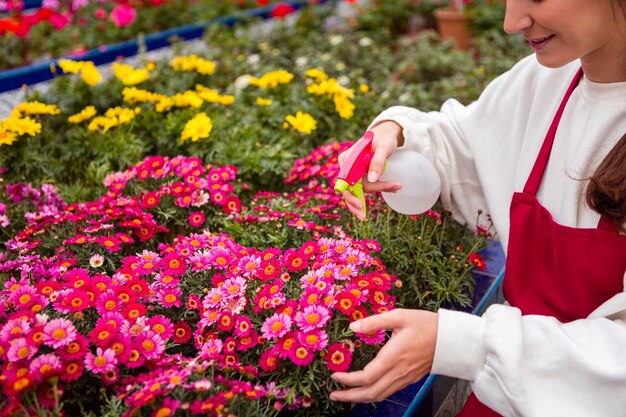 Fiori di spruzzatura della donna del primo piano in serra