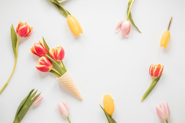 Fiori di tulipano nel cono di cialda sul tavolo