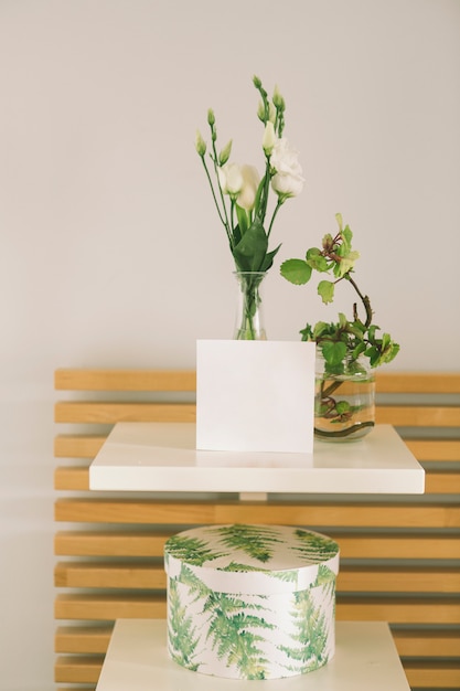 Fiori in vaso con foglio di carta bianca