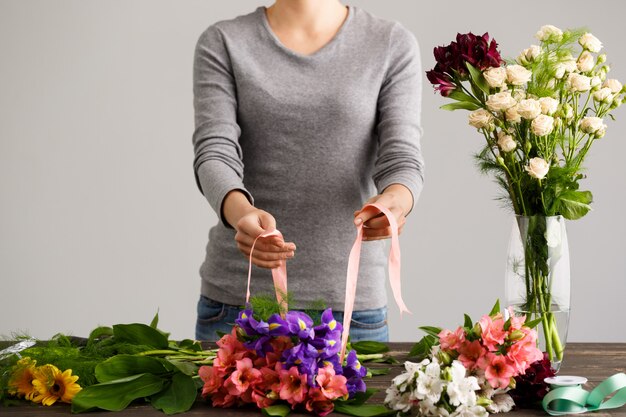 Fiorista che fa i fiori del mazzo in vaso