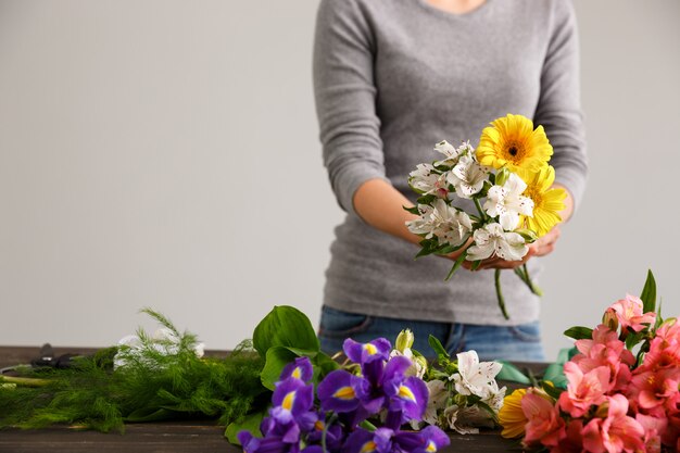 Fiorista che fa i fiori del mazzo in vaso