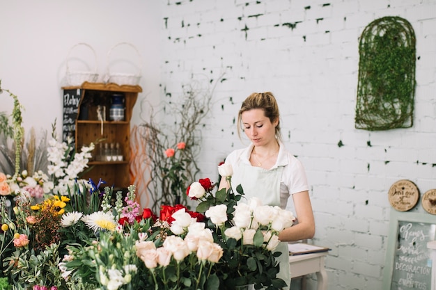 Fiorista che fa mazzi di fiori a tavola