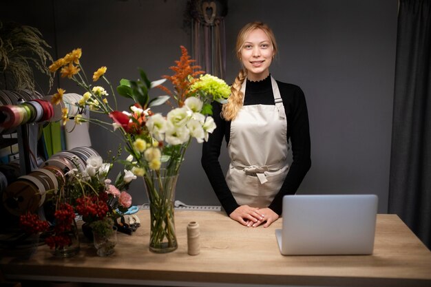 Fiorista donna che utilizza un computer portatile al lavoro